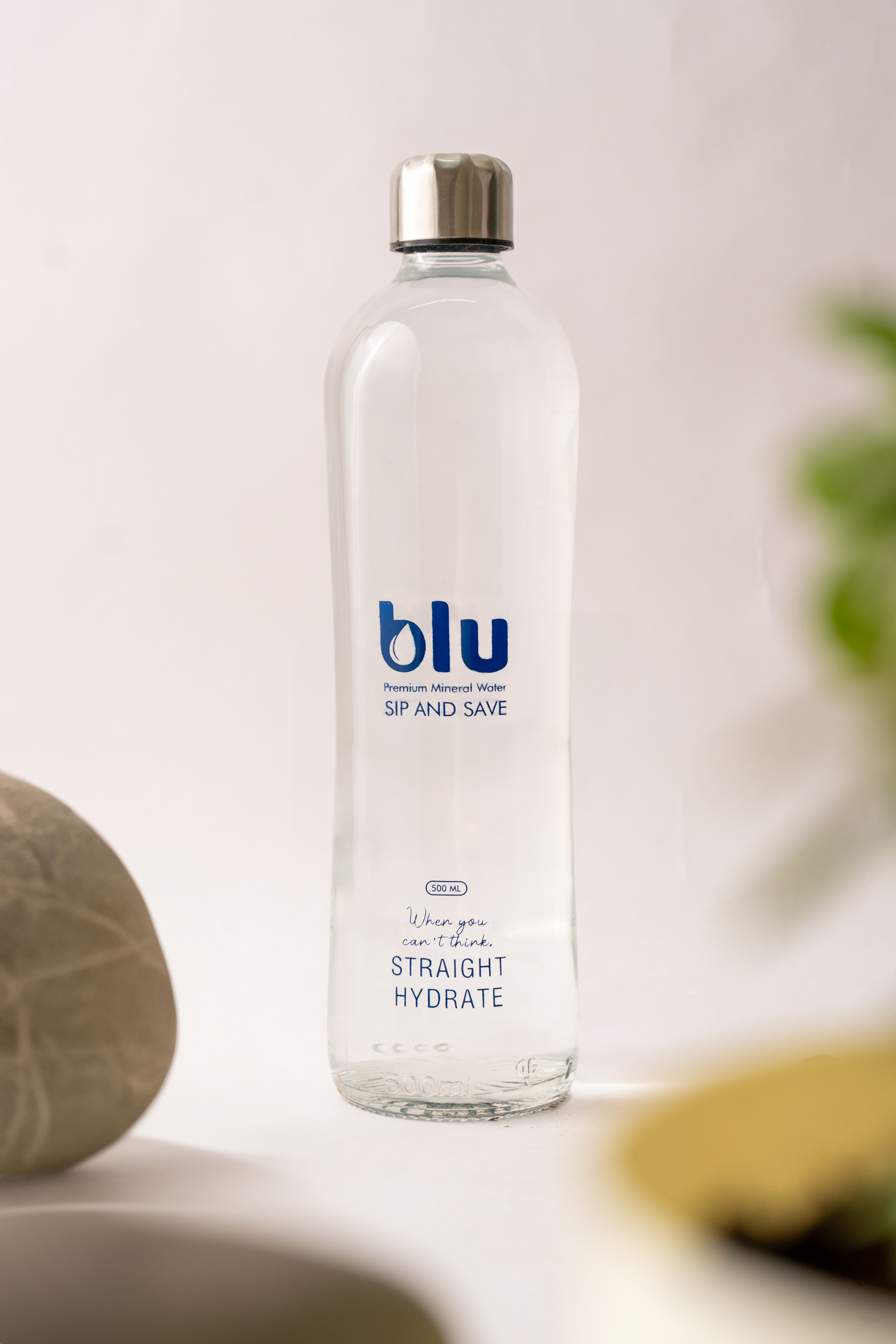 Blu Premium bottle surrounded by lush tropical greenery